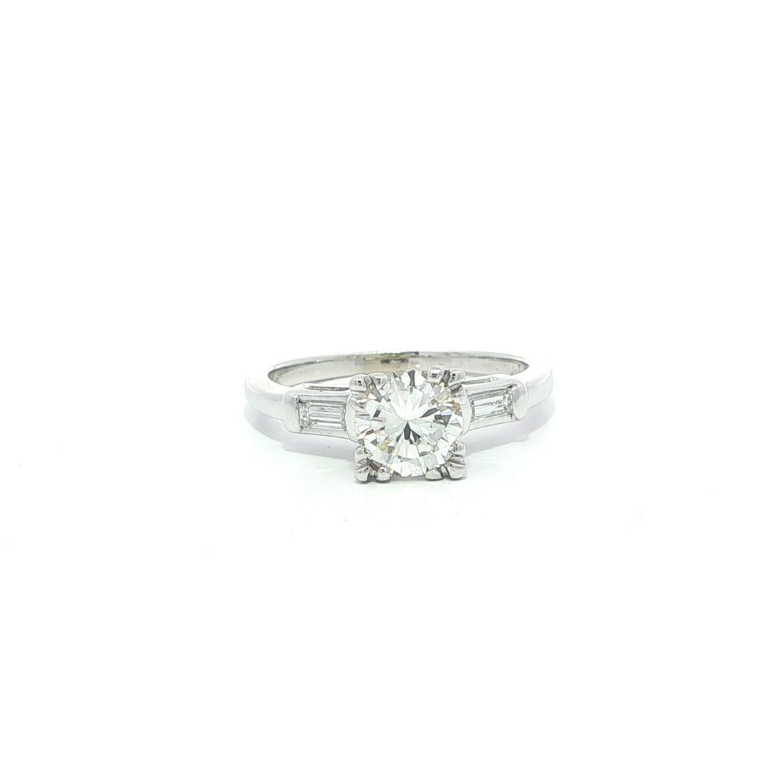 White Gold Vintage Engagement Ring with 1.02ct Round and Baguette Diamonds: White Gold Vintage Engagement Ring with 1.02ct Round and Baguette Diamonds This vintage engagement ring features a 0.90ct round brilliant-cut natural diamond prong set at the center, accompanied by tw