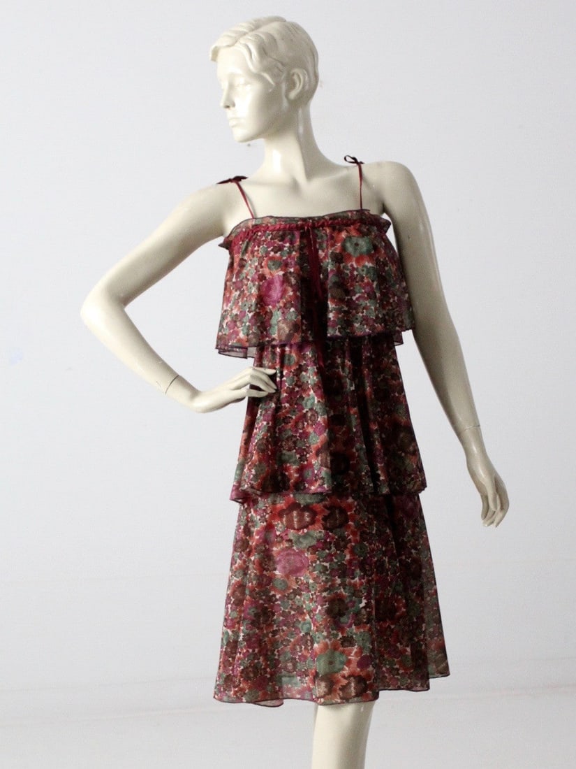 1970s Vintage Tiered Chiffon Dress with Floral Print: 1970s Vintage Tiered Chiffon Dress with Floral Print This stunning 1970s vintage tiered chiffon dress showcases a beautiful watercolor floral print in rich burgundy, rose, and green tones. The sheer d