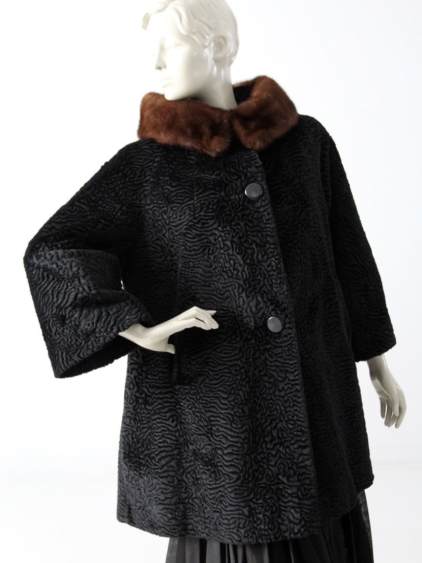 1960s Hakimlura Faux Fur Swing Coat with Mink Collar: 1960s Hakimlura Faux Fur Swing Coat with Mink Collar Step into the spotlight with this stunning vintage 1960s faux fur swing coat. Crafted in a luxurious Persian lamb style, this coat boasts a dramati