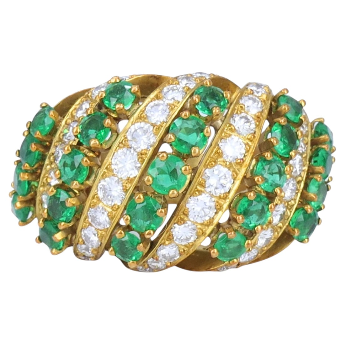 Asprey A and Co 18k Yellow Gold Emerald Diamond Crossover Ring: Asprey A and Co 18k Yellow Gold Emerald Diamond Crossover Ring Vintage cocktail ring crafted in 18k yellow gold with a wide multi-row crossover motif. It features alternating rows of round cut emerald