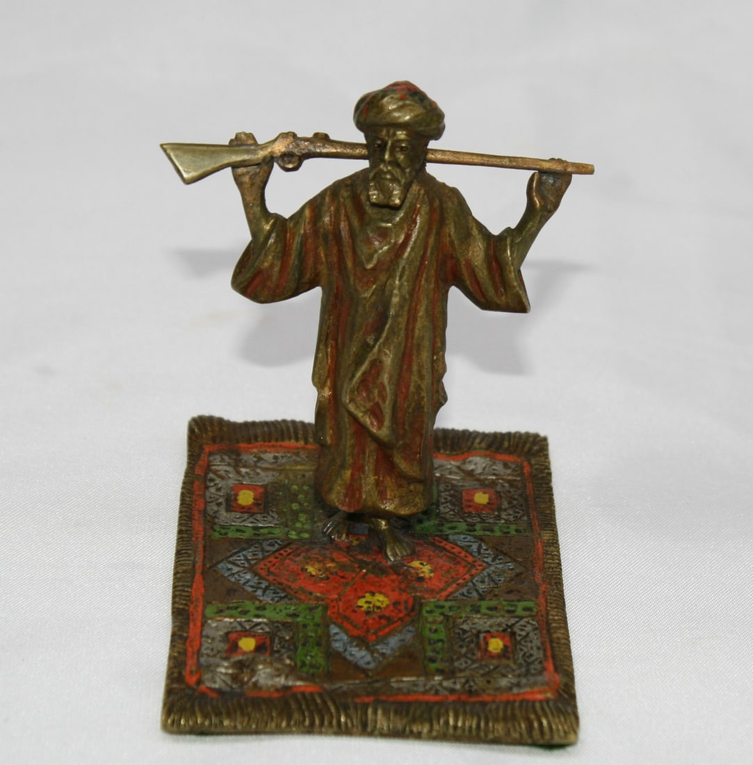 Austrian patinated bronze sculpture of Arab with rifle on rug: Austrian patinated bronze sculpture of Arab with rifle on rug A patinated bronze figure made in Austria, depicting an Arab man holding a rifle and standing on a rug. The piece features detailed modeli