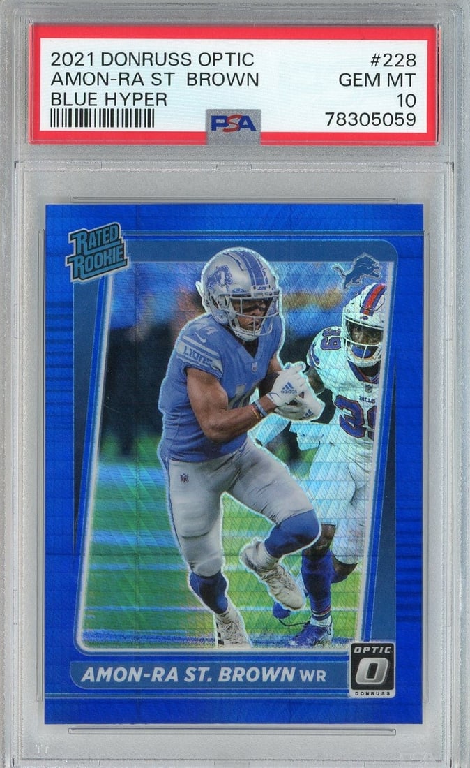 PSA 10 Amon-Ra St. Brown 2021 Blue Hyper Rookie Card #228: PSA 10 Amon-Ra St. Brown 2021 Blue Hyper Rookie Card #228 Graded 2021 Donruss Optic Amon-Ra St. Brown #228 Blue Hyper rookie sports trading card. This football card features Amon-Ra St. Brown of the D