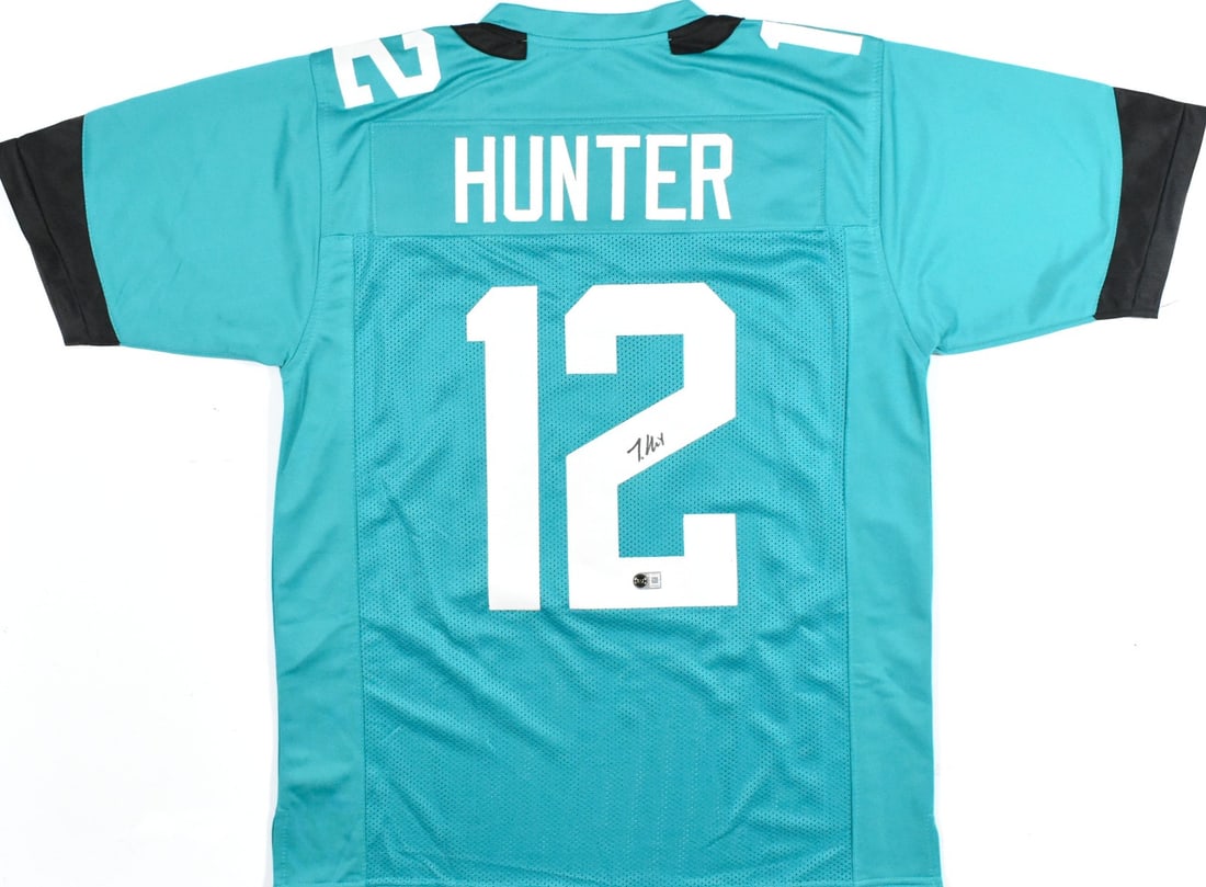 Teal Pro Style Football Jersey Signed by Travis Hunter with Beckett Hologram: Teal Pro Style Football Jersey Signed by Travis Hunter with Beckett Hologram Autographed teal pro style football jersey featuring Travis Hunter. This pre-owned piece is authenticated by Beckett Authen