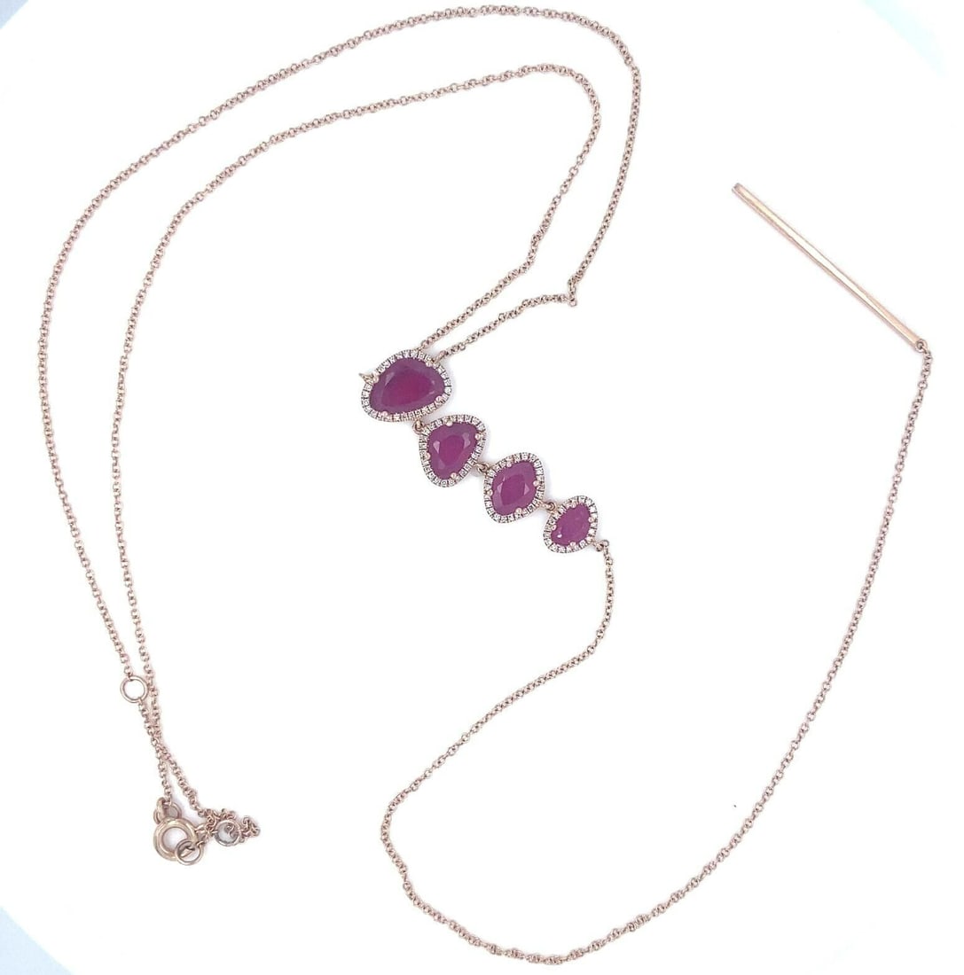 Unbranded 14k Rose Gold Lariat Necklace with Ruby and 0.64 ct Diamond: Unbranded 14k Rose Gold Lariat Necklace with Ruby and 0.64 ct Diamond Unique ruby and diamond drop lariat necklace crafted in 14k rose gold. This pre-owned necklace features four faceted asymmetrical 