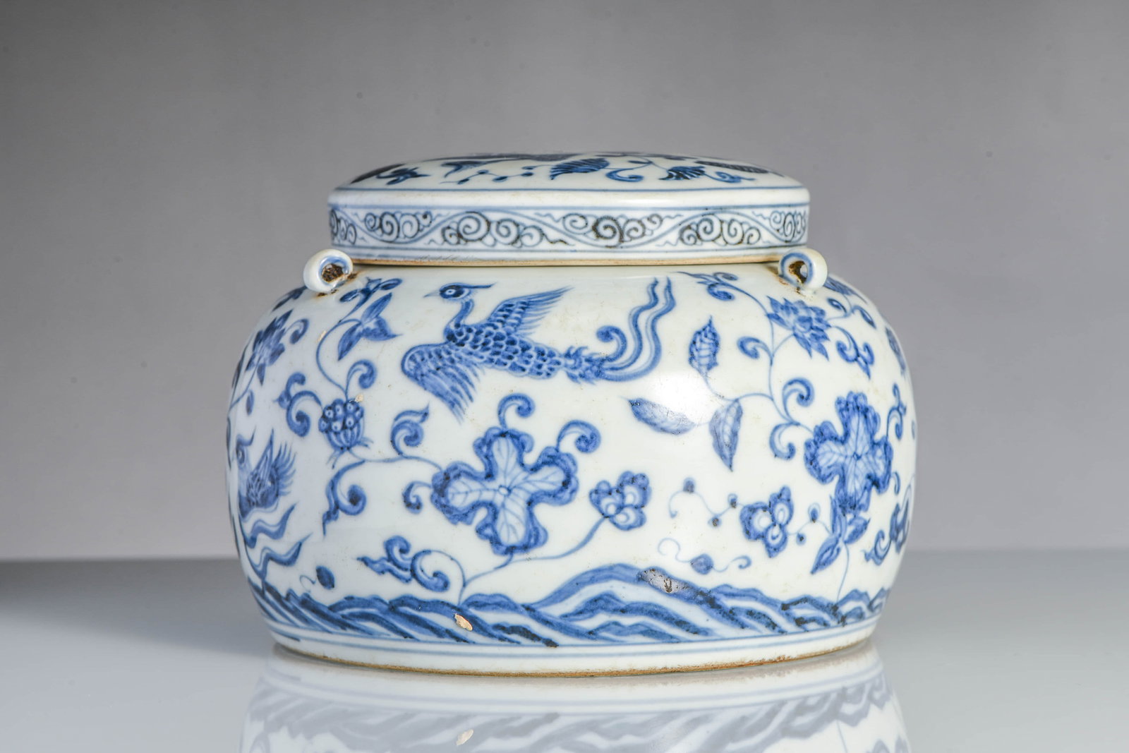 Blue and White Patterned Scroll-Leaf Lotus and Phoenix-Decorated Three-Layered Cover Vase: BLUE AND WHITE PATTERNED SCROLL-LEAF LOTUS AND PHOENIX-DECORATED THREE-LAYERED COVER VASEDescription:Item: Made in the reign of Emperor Ming of the Chongde Dynasty Width: 16 cm x Height: 11.2 cm