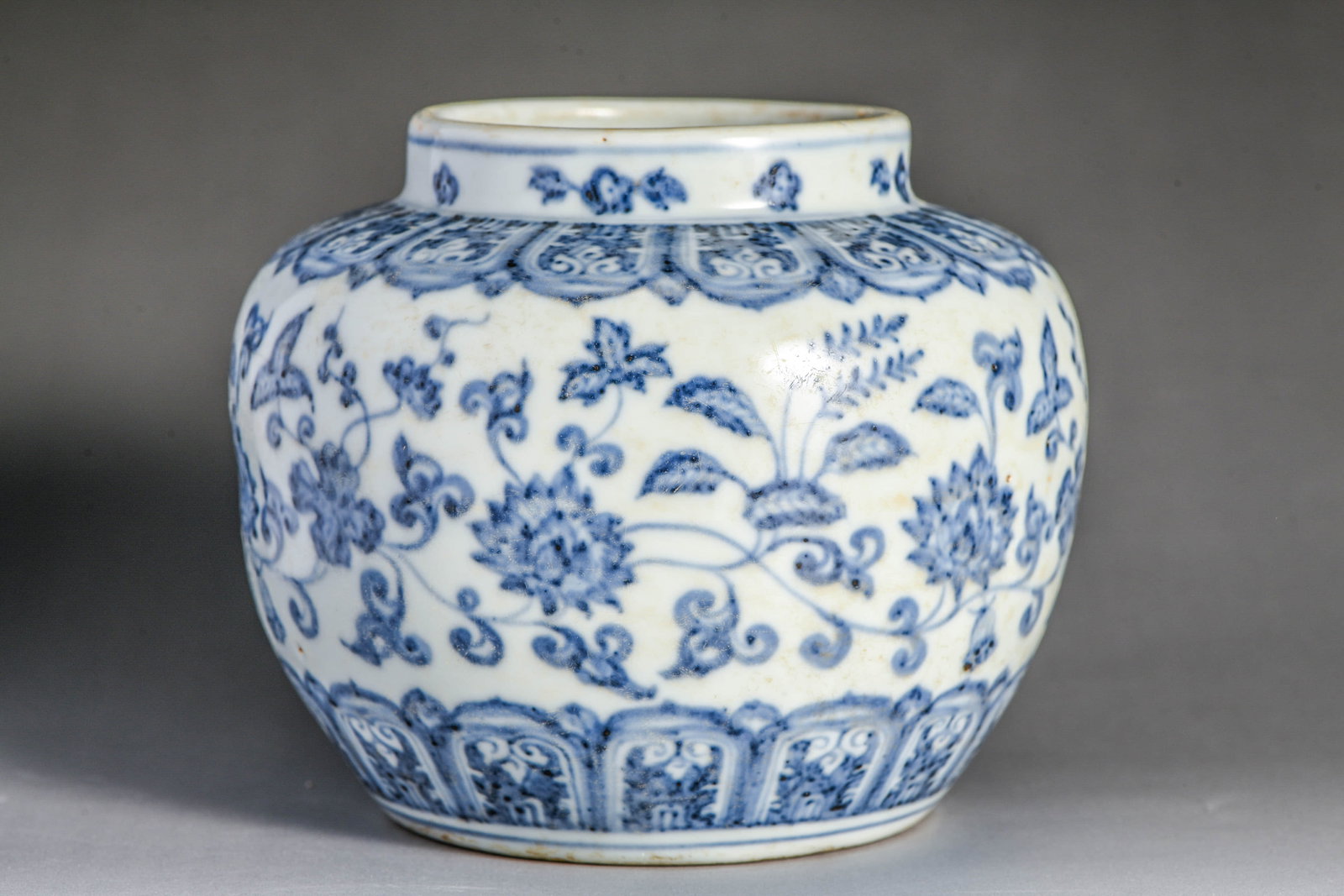 Blue and white scroll-leaf lotus pattern small jar: BLUE AND WHITE SCROLL-LEAF LOTUS PATTERN SMALL JAR Description: Item: Made in the reign of Emperor Ming of the Chongde Dynasty Width: 12.5 cm x Height: 11 cm