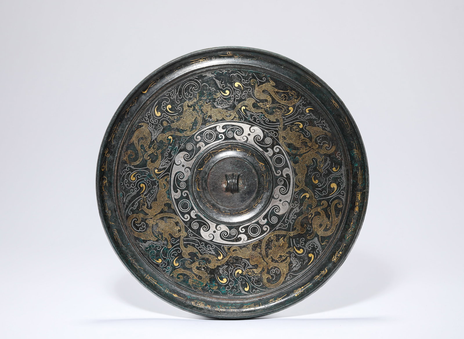 A Gold and Silver-Inlaid Bronze 'Auspicious Beast' Mirror: Description: Dimensions: Weight: 682 g. Width: 19.3 cm. All measurements are approximate.