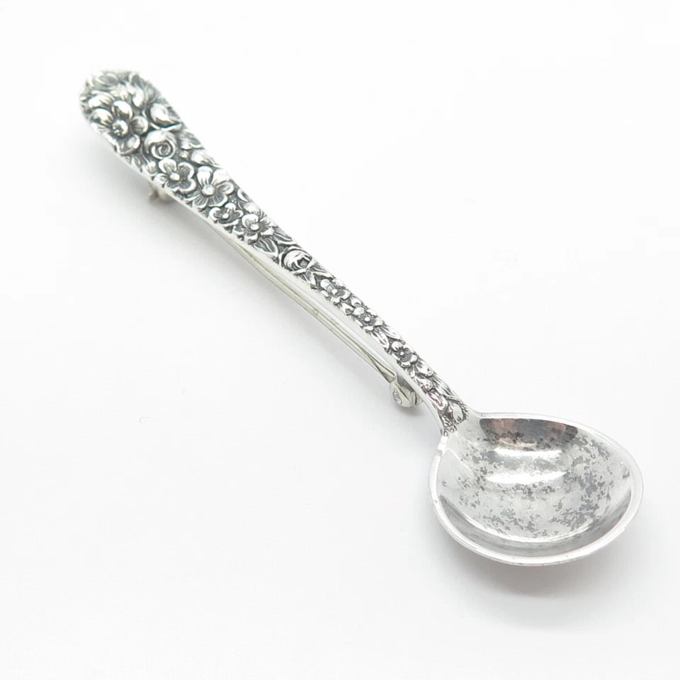 Vintage Silver-Tone Floral Spoon Brooch: VINTAGE SILVER-TONE FLORAL SPOON BROOCH Provenance and Authenticity: This object is presented as a vintage silver-tone spoon-form brooch featuring an elongated floral-decorated handle and a shallow ro