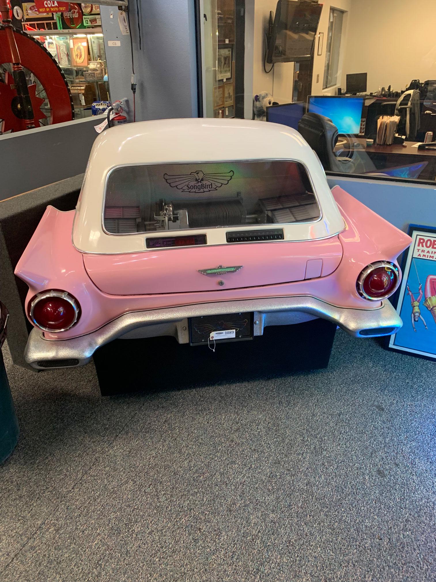 Songbird '57 Thunderbird Jukebox: This rare jukebox has a pink 1957 Ford Thunderbird style fiberglass body with a white top that fits flush against a wall. It currently has 6 of the 80 slots for 45 rpm vinyl records full and the same