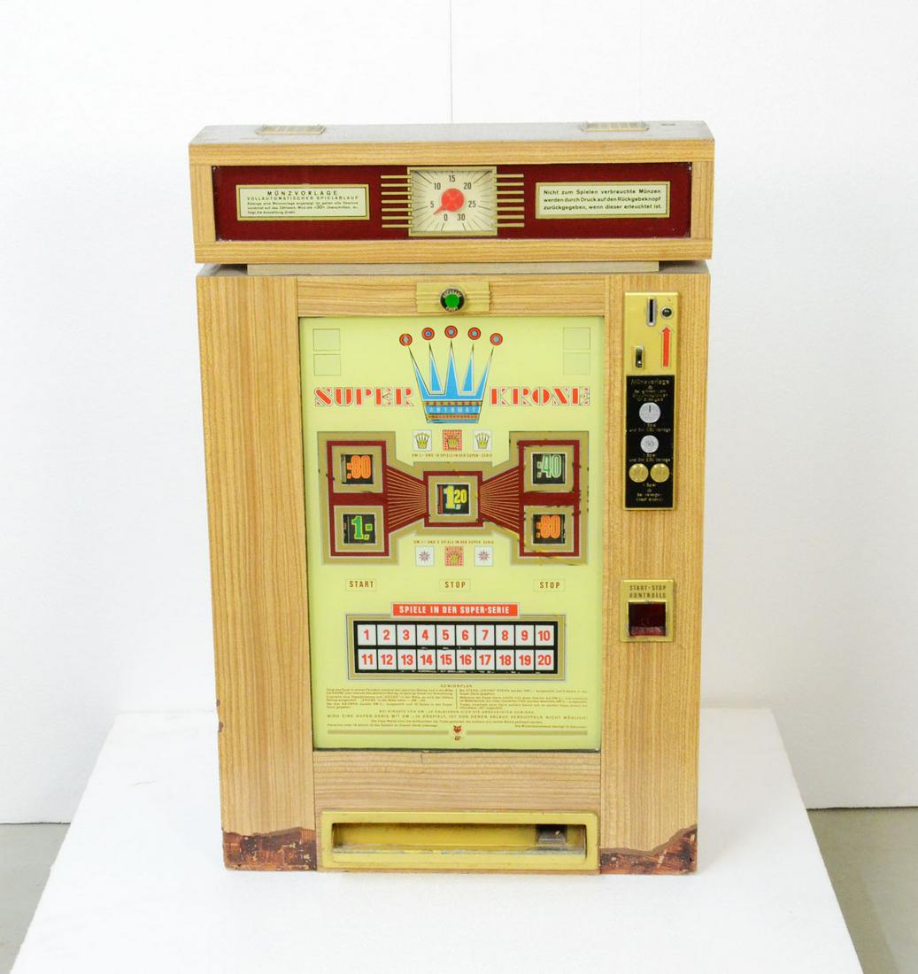 German slot machine Super Krone: German slot machine Super Krone. Playable. Good visual condition, missing the decorative top layer in a few spots. Size: 88,5 x 57 x 23 cm. Condition: Good. Location: The Netherlands