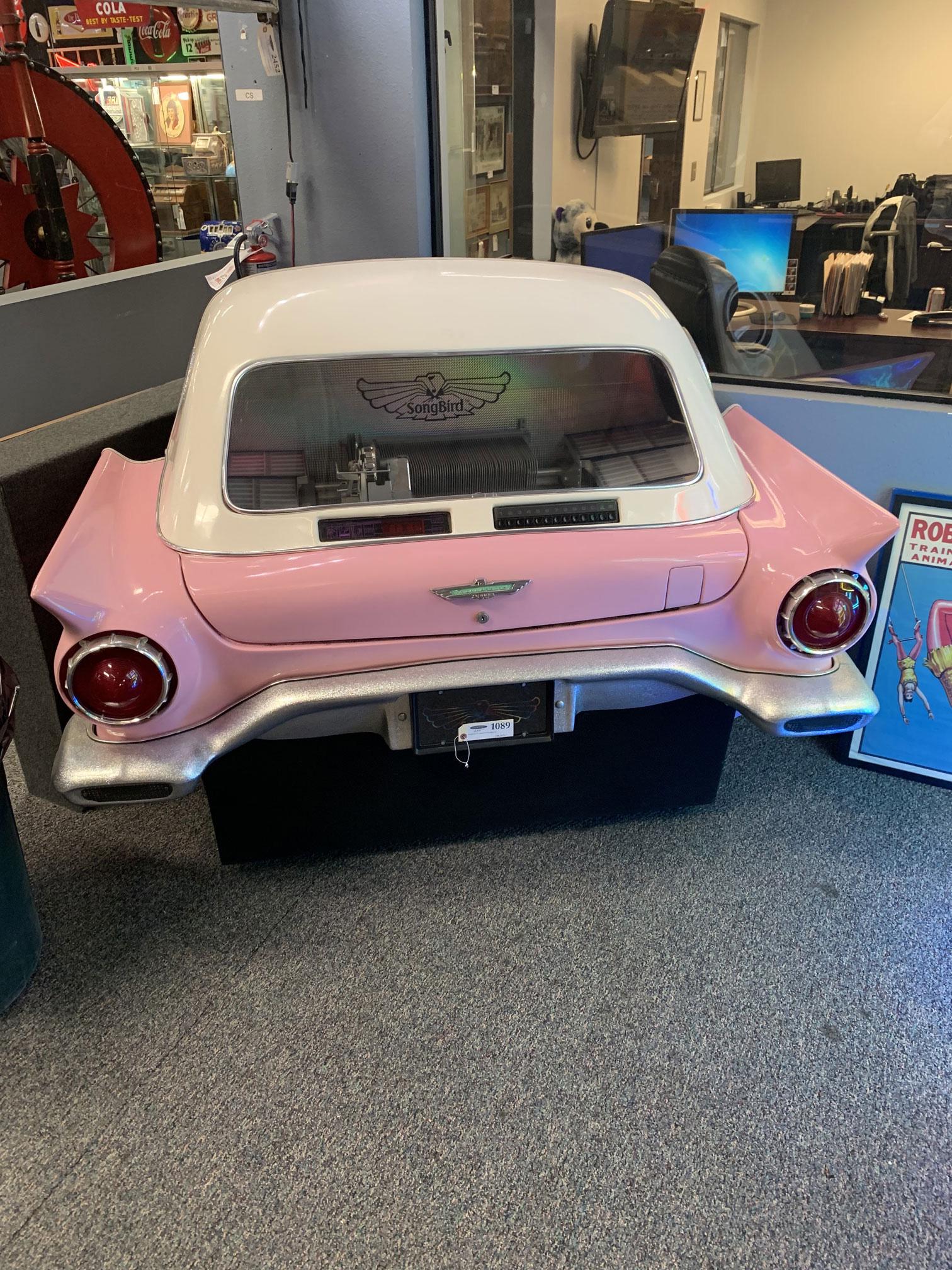 Songbird '57 Thunderbird Jukebox: This rare jukebox has a pink 1957 Ford Thunderbird style fiberglass body with a white top that fits flush against a wall. It currently has 6 of the 80 slots for 45 rpm vinyl records full and the same
