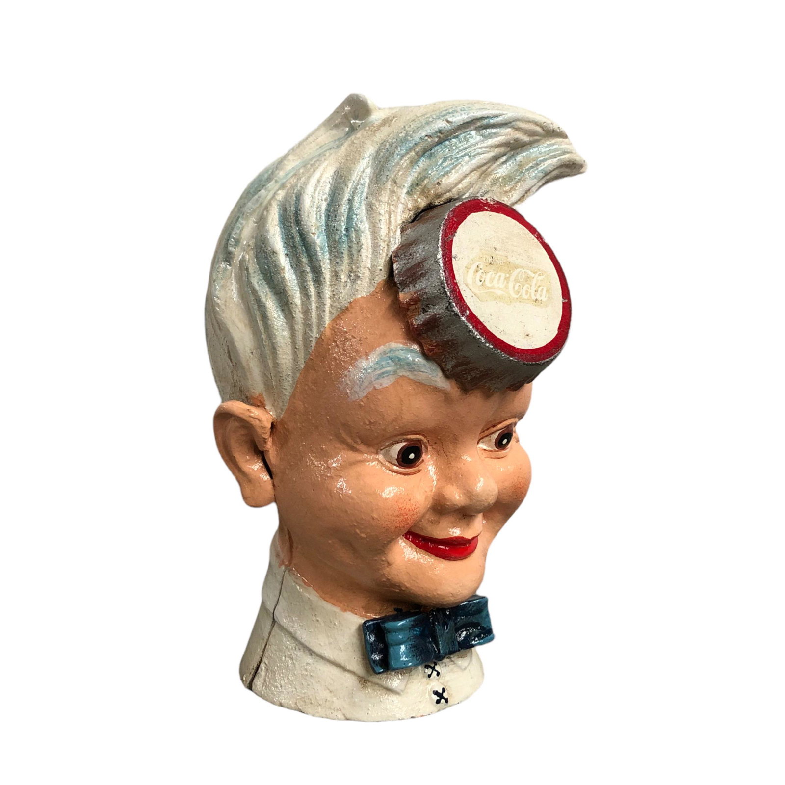 Reproduction Coca-Cola Sprite Boy Cast Iron Coin Bank: Reproduction Coca-Cola Sprite Boy cast iron coin bank. The red color of the Coca-Cola logo has faded leaving only the outline of the letters. Size: 20 x 13 x 14 cm. Condition: Very Good. Location: The