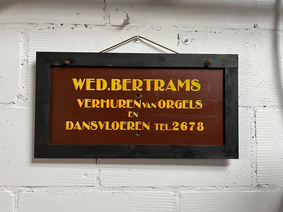 Dutch Advertising Sign Wed. Bertrams: Dutch advertising sign Wed. Bertrams. Text on the sign translated from Dutch - Wed. Bertrams, Renting out organs and dance floors. Tel. 2678. Wooden sign with two mounting holes in the middle in a woo