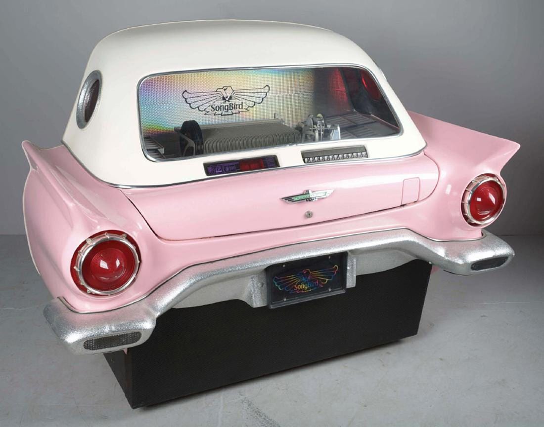 Songbird '57 Thunderbird Jukebox: This rare jukebox has a pink 1957 Ford Thunderbird style fiberglass body with a white top that fits flush against a wall. It currently has 6 of the 80 Slots for 45 rpm vinyl records full and the same