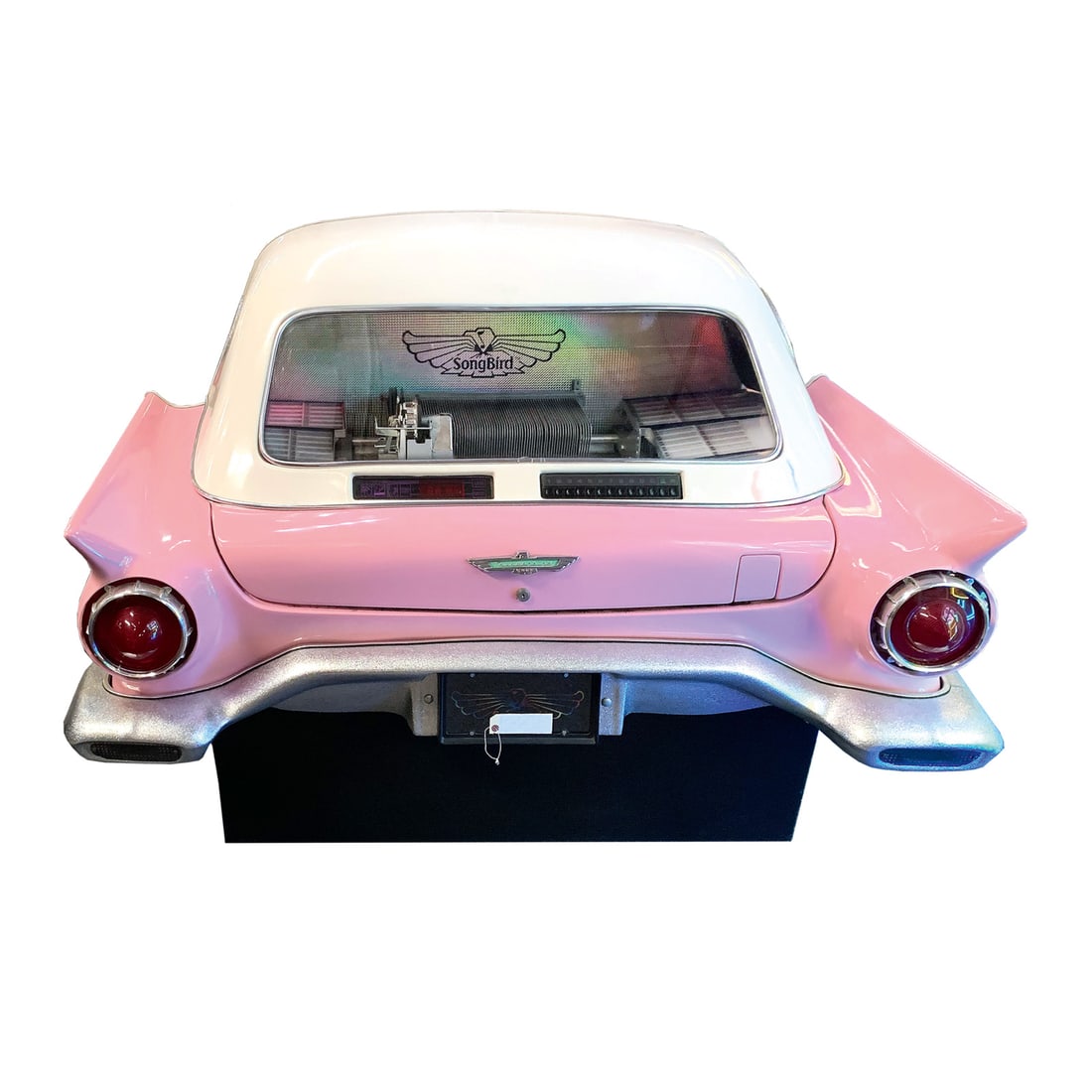 1988 Songbird '57 Thunderbird Jukebox: This rare jukebox has a pink 1957 Ford Thunderbird style fiberglass body with a white top that fits flush against a wall. It currently has 6 of the 80 Slots for 45 rpm vinyl records full and the same