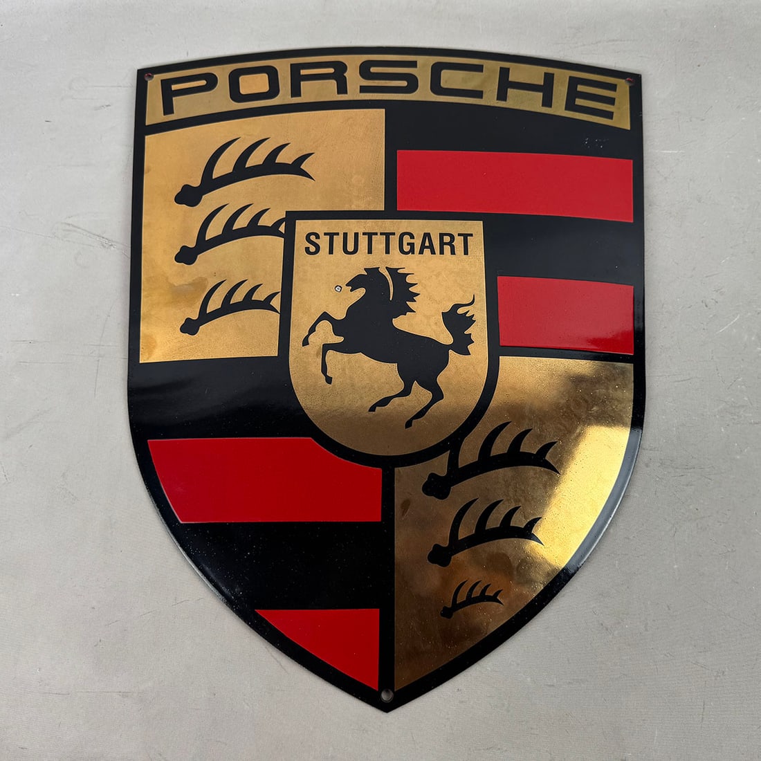 Porsche Logo Enamel Sign with 14 Karat Gold Plating: Porsche logo enamel sign with 14 karat gold plating. Very good visual condition, has a spot of enamel loss on front center. Dimensions (H x W x D): 45 x 35 x 1 cm. Condition: Very Good. Location: The 