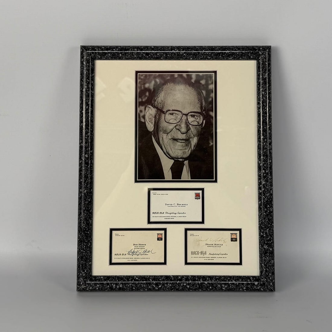 Framed Original Business Cards of the Rock-Ola Management Team in the 1990's : Framed origianl business cards of the Rock-Ola management team in the 1990's - David C. Rock-Ola, Bob Hesch with signature and Frank Schulz with signature. Excellent visual condition, showing minimal 