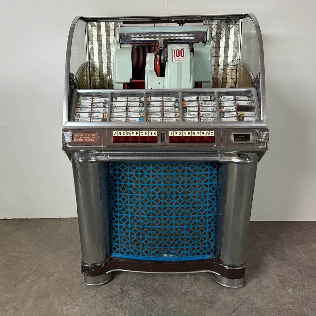1953 Seeburg HF100G jukebox : 1953 Seeburg Model EHF100G-5 jukebox. 100 selections of 45 RPM records. Visual condition: in fair visual condition, missing the dome and upper back door. Technical condition: currently in a not playin