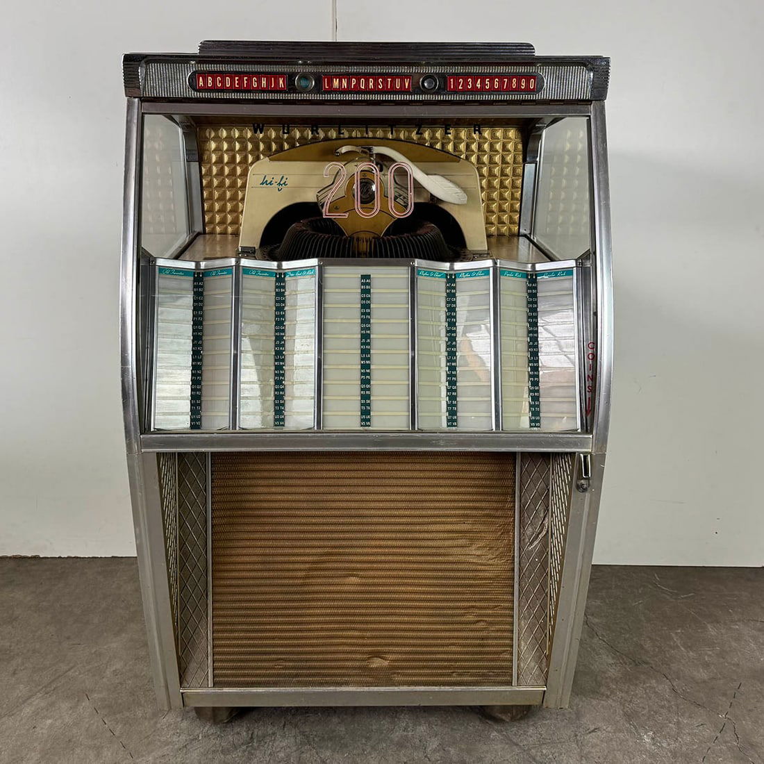 1957 Wurlitzer Model 2150 Jukebox: 1957 Wurlitzer Model 2150 jukebox. 200 selections of 45 RPM records. Visual condition: good original visual condition, showing some wear and dents in the speaker grill. Missing lower back door. Techni