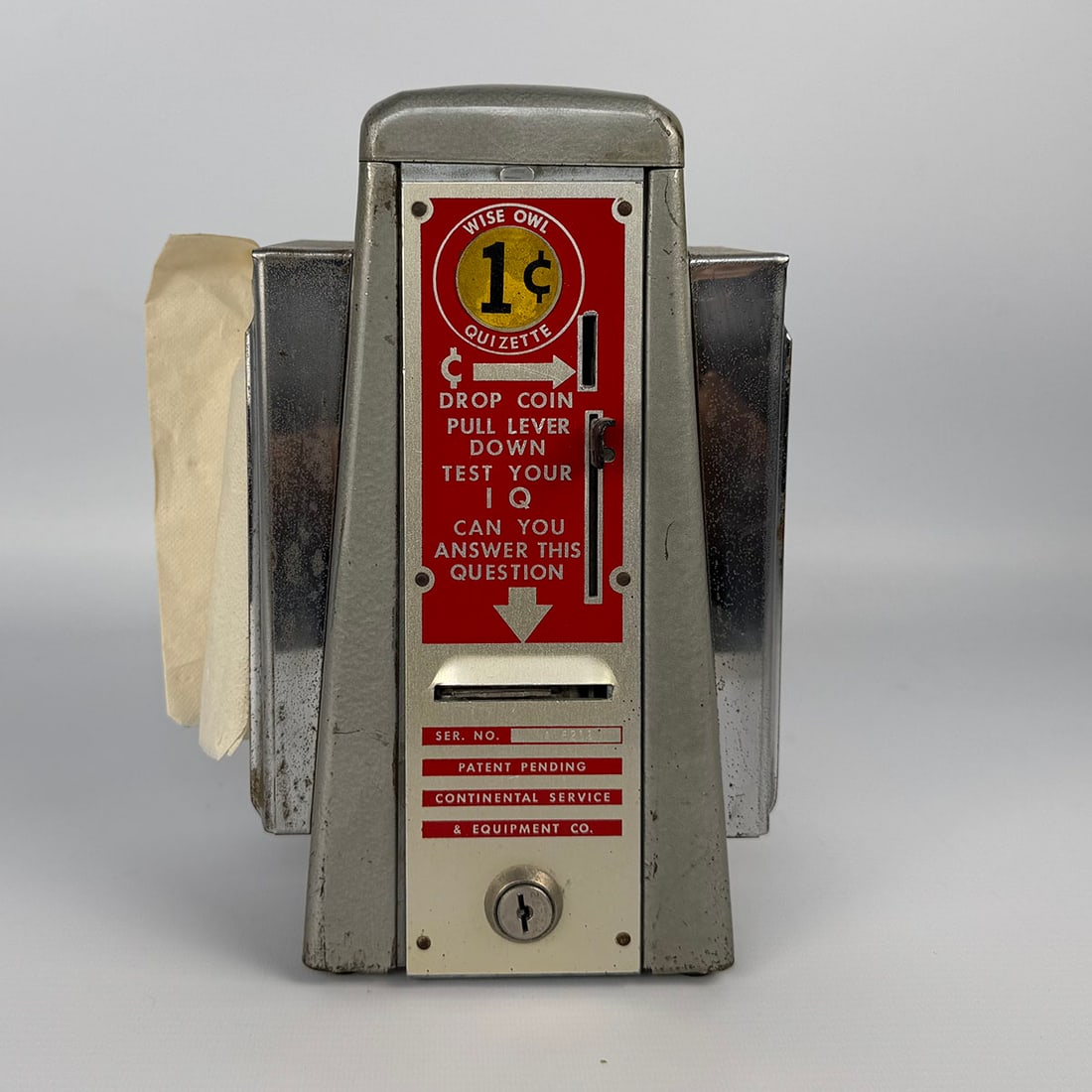 Continental Service & Equipment Co. 1 Cent "Wise Owl Quizette" with Napkin Dispensers ca. 1950: Continental Service & Equipment Co. 1 Cent "Wise Owl Quizette" with Napkin Dispensers ca. 1950. Good visual condition, showing wear to the case. Comes with the key. Dimensions (H x W x D): 26 x 17 x 1