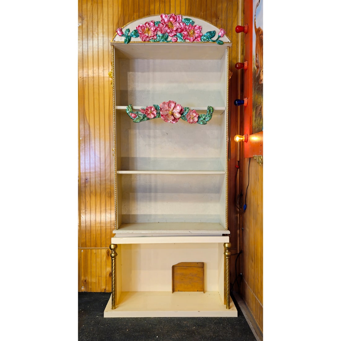 Empty Wooden Shelf Used to Store Wurlitzer Style 165 Military Band Organ Music Rolls: Empty wooden shelf with OSB backing board, metal columns, plastic floral ornaments and a wooden horse head ornament with a glass eye. Bill Nunn used this shelf to store Wurlitzer Style 165 Military Ba
