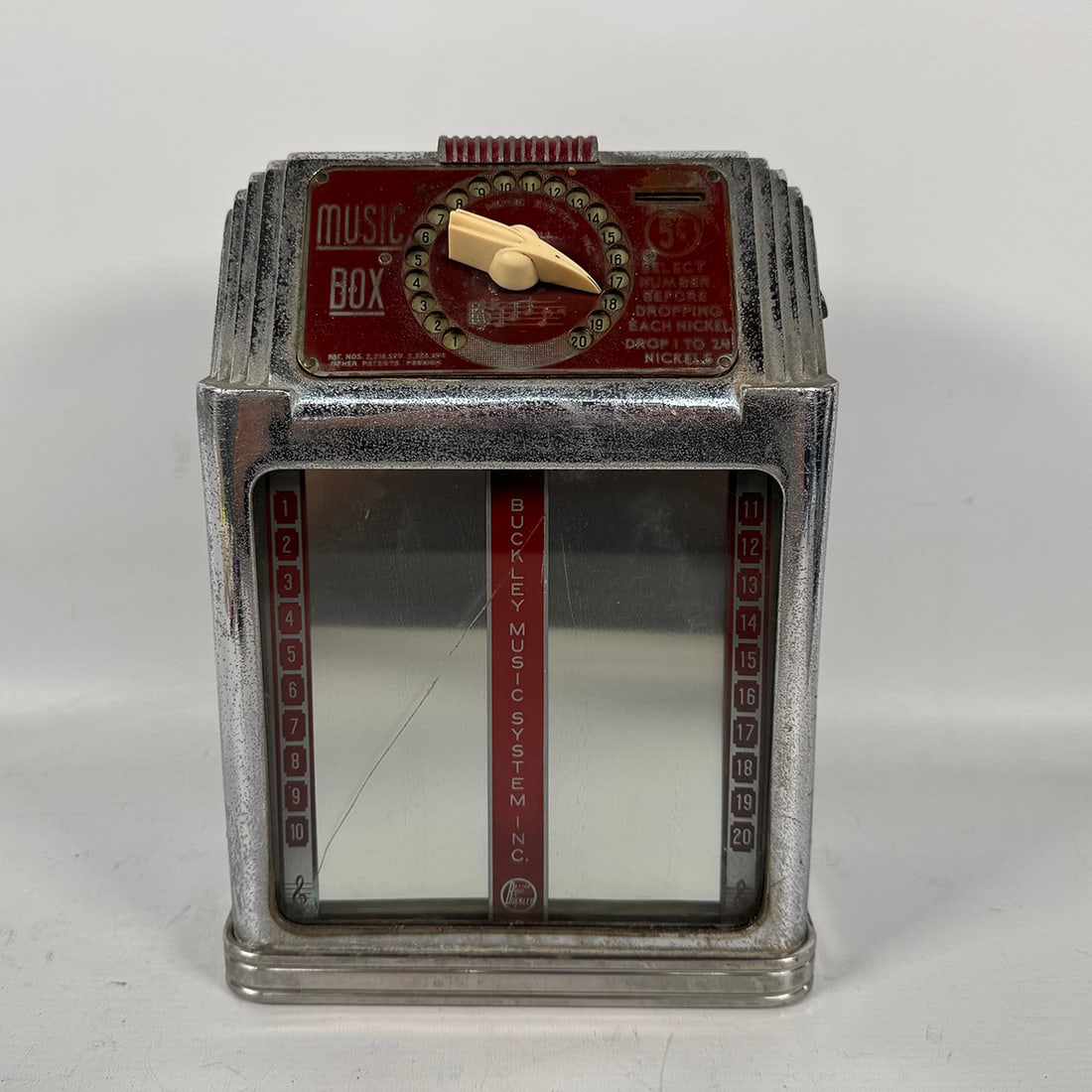 Buckley "Music Box" Wallbox (1939-1958): Buckley "Music Box" Wallbox (1939-1958). Fair visual condition, heavily worn chrome, a large scrape on the front glass original side plastics have been replaced with custom made ones. Comes with key,