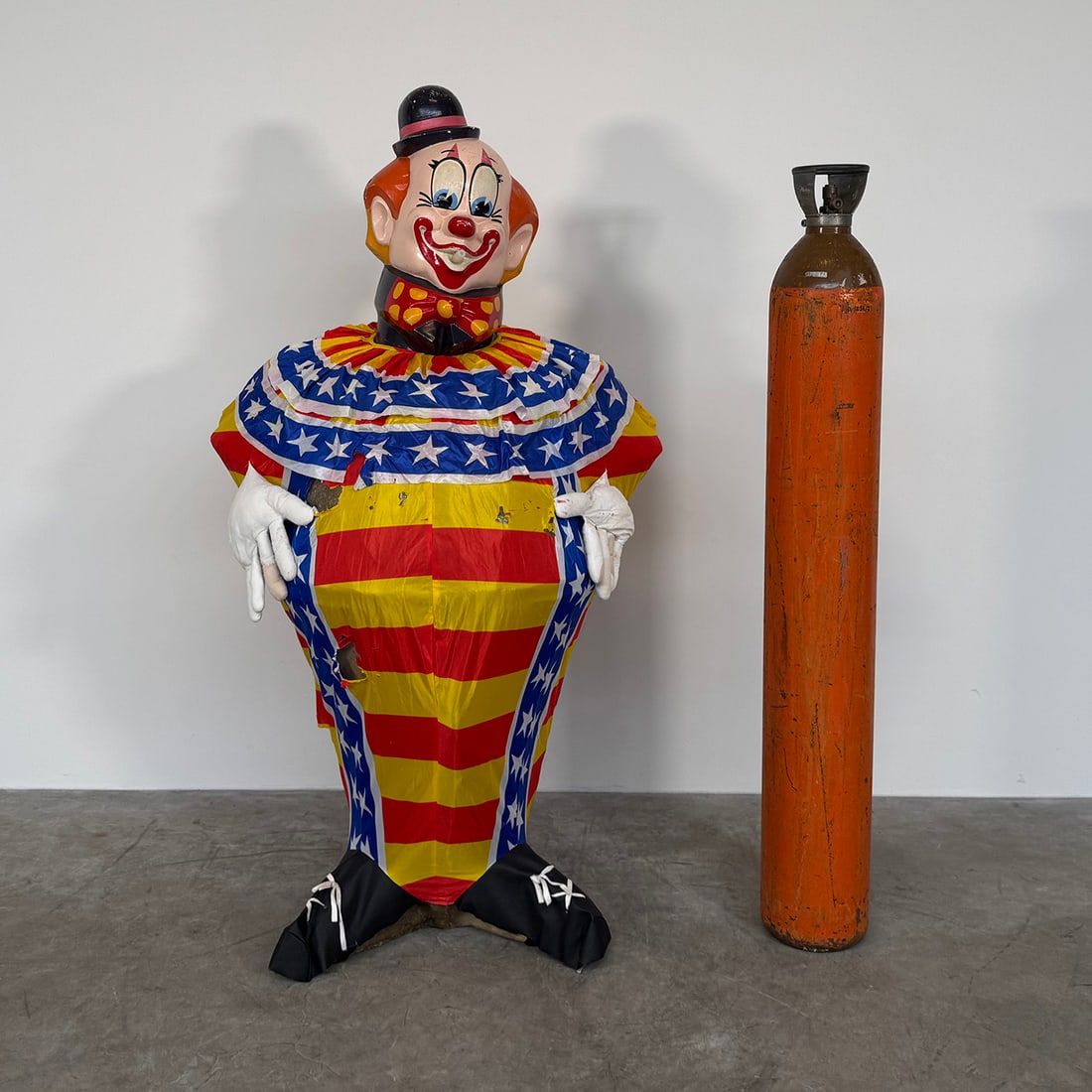 B50 Helium Tank Cover Designed in the Shape of Circus Clown: This fiberglass clown figure is designed to fit over a large B50 helium tank, featuring a hollow interior and a classic circus-themed costume with a top hat and a red-and-white striped jacket. The set