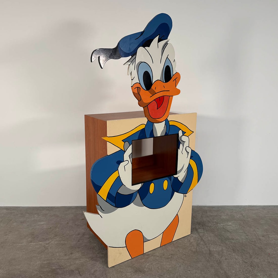Wooden TV Cabinet Designed in the Shape of Donald Duck Disney Character: Wooden TV cabinet designed in the shape of Donald Duck Disney character, featuring a vibrant blue, yellow, and white color palette with a rectangular screen opening positioned in the torso. The unit a