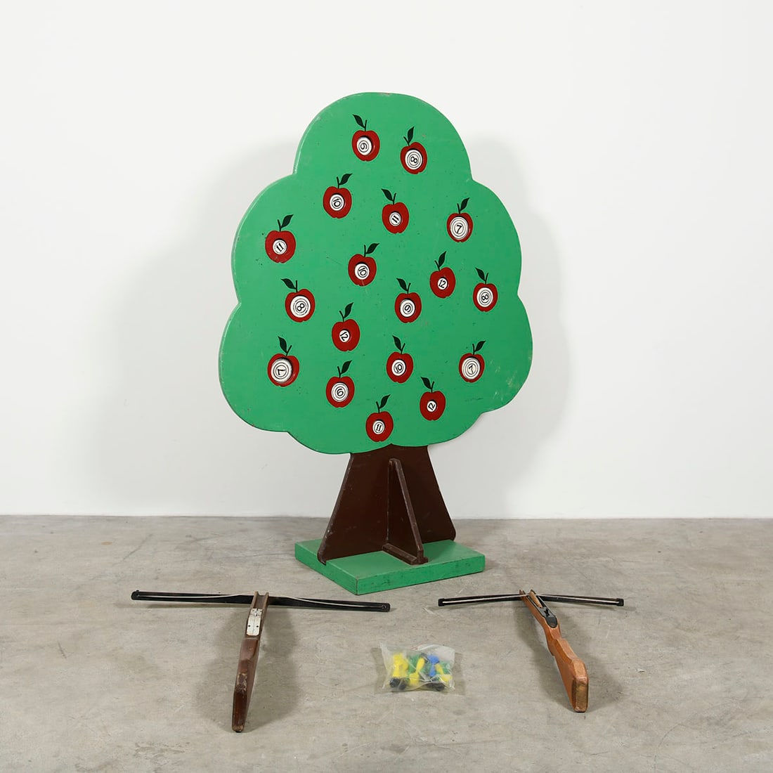 Wooden Apple Tree Silhouette Shooting Game with 2 Crossbows and 10 Plastic Darts: This interactive skill game features a large wooden silhouette of an apple tree with numbered targets marked by red apples. The set is accompanied by two handheld wooden crossbows and a set of 10 plas