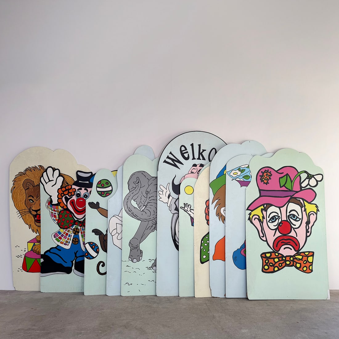 Lot of 11 Hand-painted Wooden Circus Panels: This lot of 11 hand-painted wooden circus panels. Each vertical panel features a unique, vibrantly colored illustration depicting classic circus and fairground themes, including performing animals and