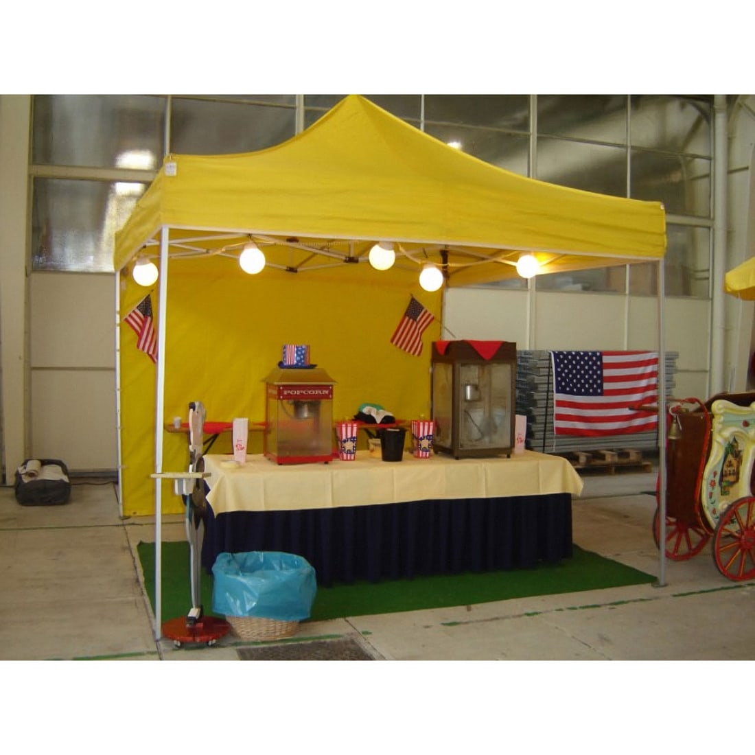 Yellow Professional 3 x 3 m Aluminum Expo Tent with Side Walls and Weights: This yellow professional 3 x 3 meter aluminum Expo tent is designed for high visibility and durability. The set includes a black storage crate containing four matching side walls. To ensure stability