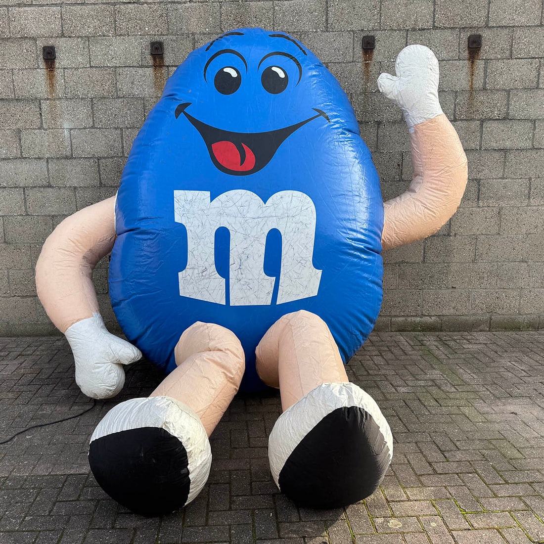 Large inflatable Blue M&M Character Promotional Unit: Large inflatable Blue M&M character promotional unit. Constructed from durable, weather-resistant PVC, the figure includes internal structural supports and a integrated air-intake system protected by