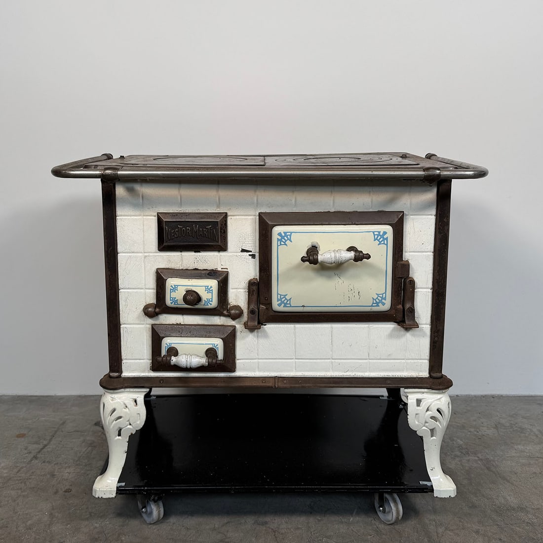 Early 20th Century Belgian Nestor Martin Cast Iron Wood Stove with Tiles and Porcelain Enamel: Early 20th century Belgian Nestor Martin cast iron wood stove with tiles and porcelain enamel. Good visual condition showing regular wear, some rust and spots of enamel loss. Dimensions (H x W x D): 8