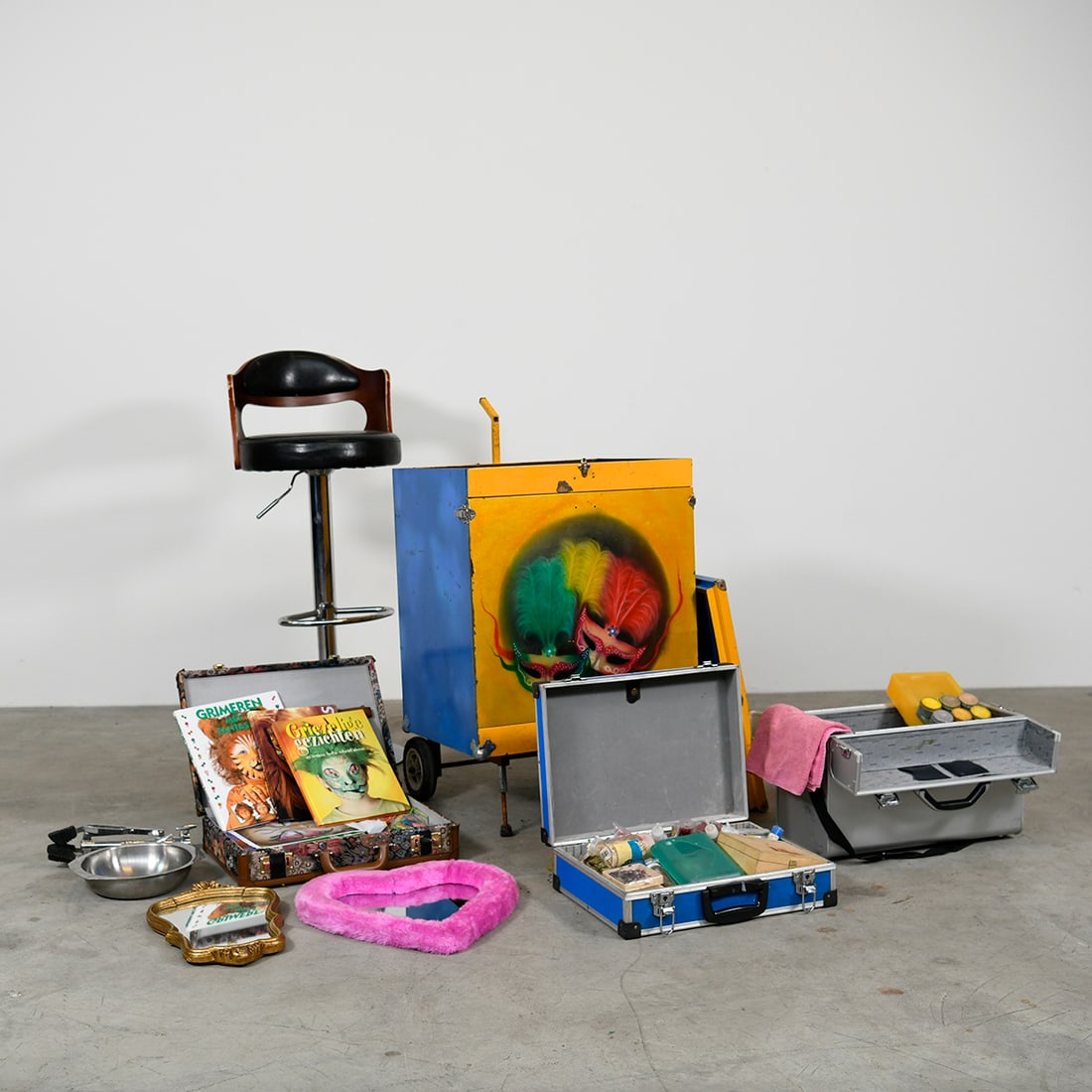 Mobile Face-painting Station with Many Accessories - "The Painted Performer's Chest": "The Painted Performer's Chest" is a mobile face-painting station featuring a vibrant, airbrushed metal trolley decorated with colorful masquerade mask motifs. This comprehensive kit includes a height