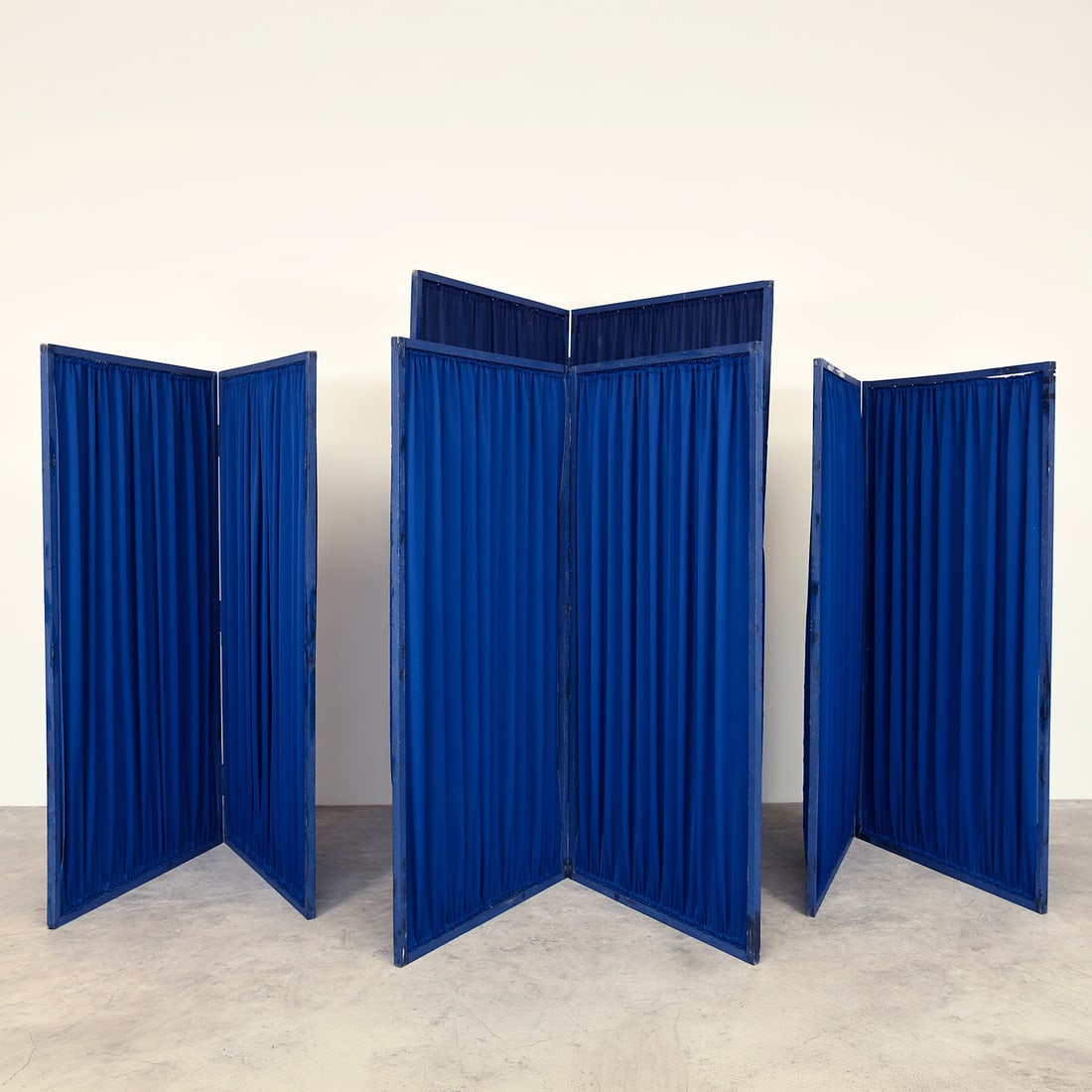 Set of 4 Wooden Folding Screens with Blue Fabric Panels from the Royce Collection: Set of four folding room dividers with wooden frames and pleated blue fabric panels, from the Royce Collection. Each screen consists of hinged sections that can be arranged in different positions, mak