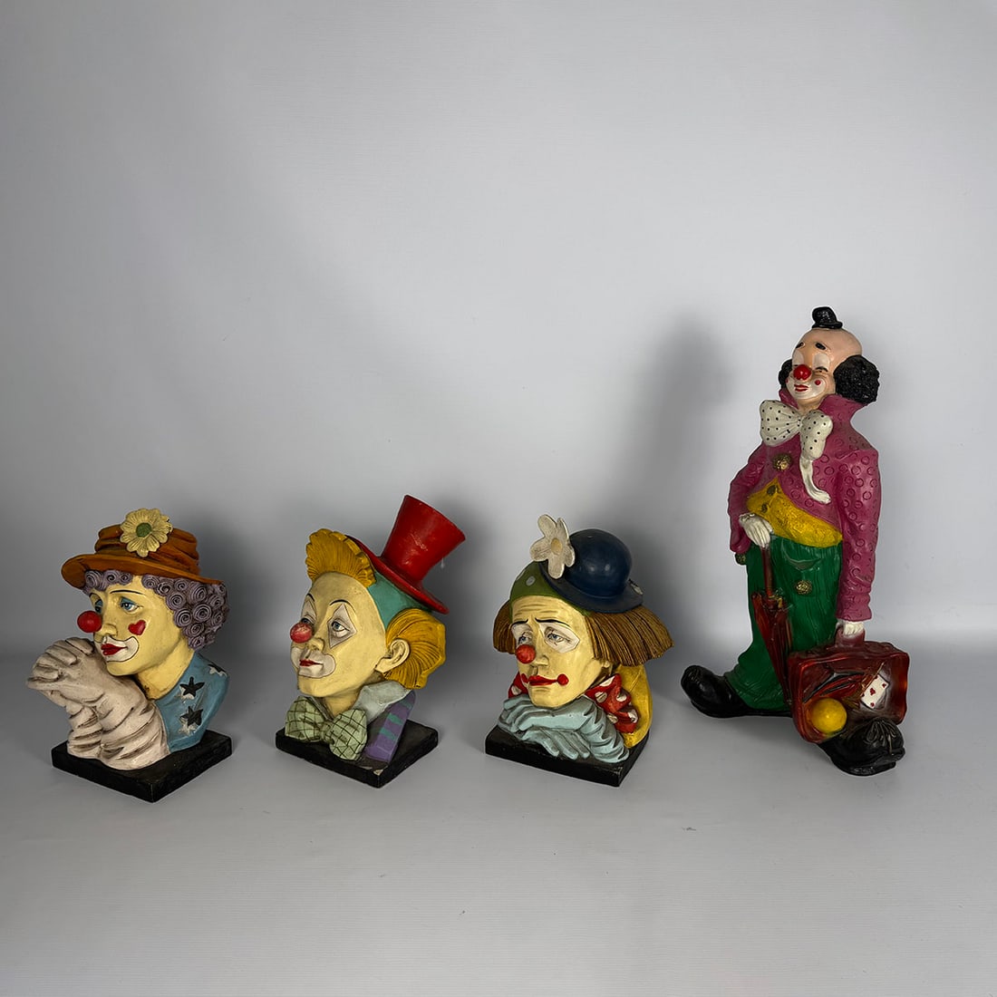 Set of 4 clown figures: Lot of four decorative clown figures, including three busts and one standing clown. Colorfully painted with circus-style details, suitable as decorative or display pieces. Condition: Used with signs