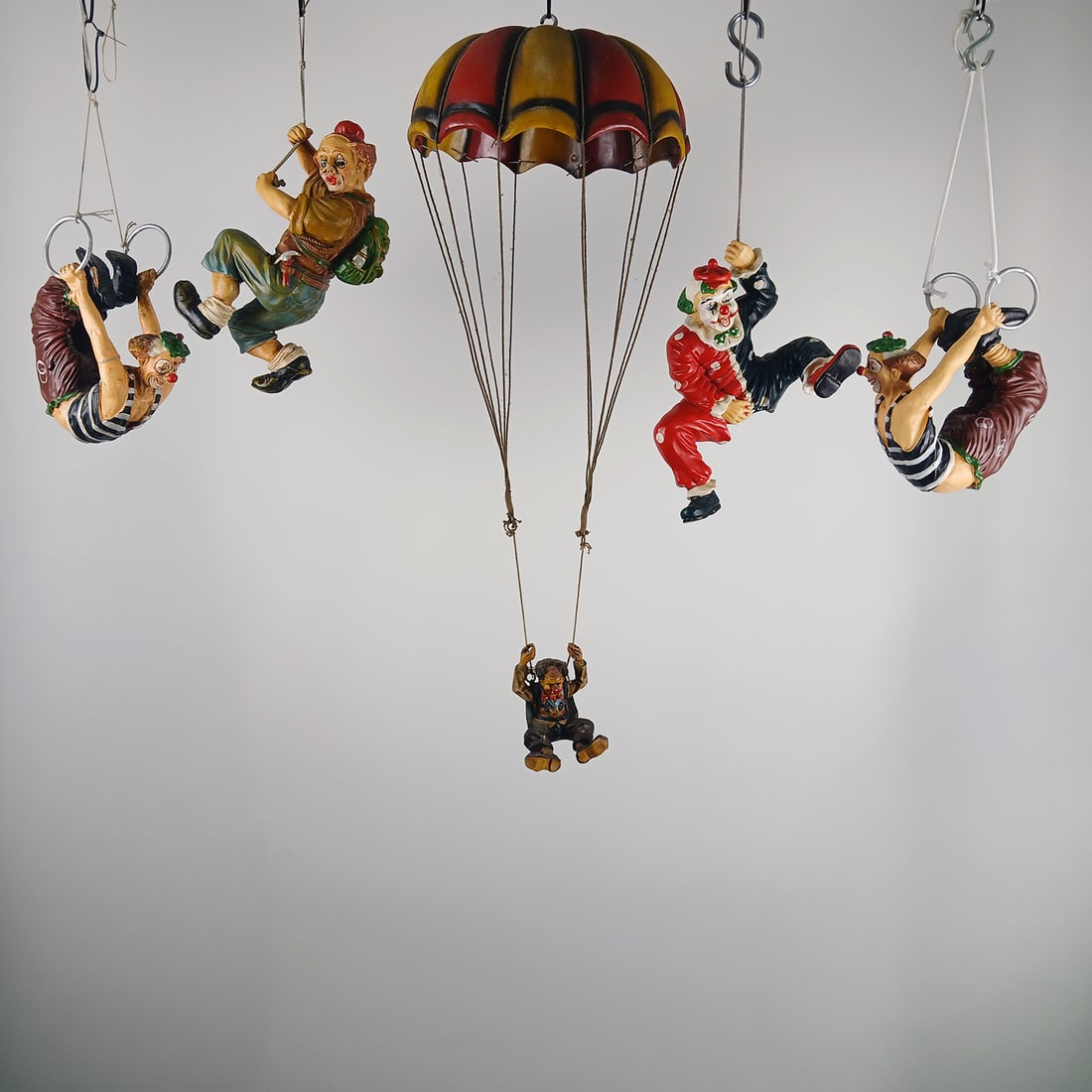 Lot of 5 Decorative Hanging Clown Figures: Lot consisting of five small decorative clown figures designed to hang as playful circus-themed ornaments. The lot includes a clown hanging with a backpack, two clowns performing on gymnastic rings,