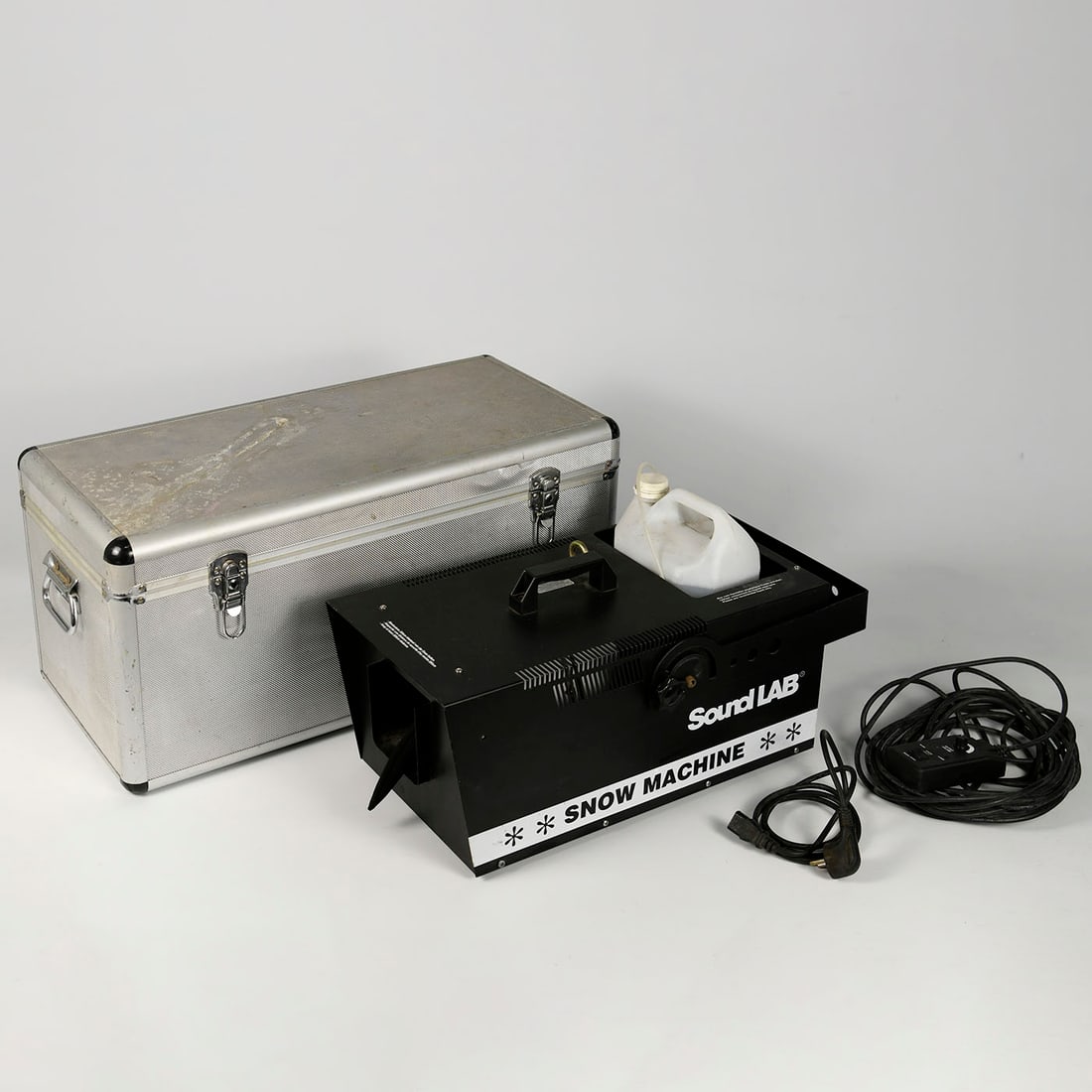 Black snow machine in aluminum case incl. can with 5 liters of snow fluid: SoundLAB snow machine supplied with an aluminum transport/storage case. The lot includes a container with approximately 5 liters of snow fluid. Suitable for stage effects, events, theatrical productio