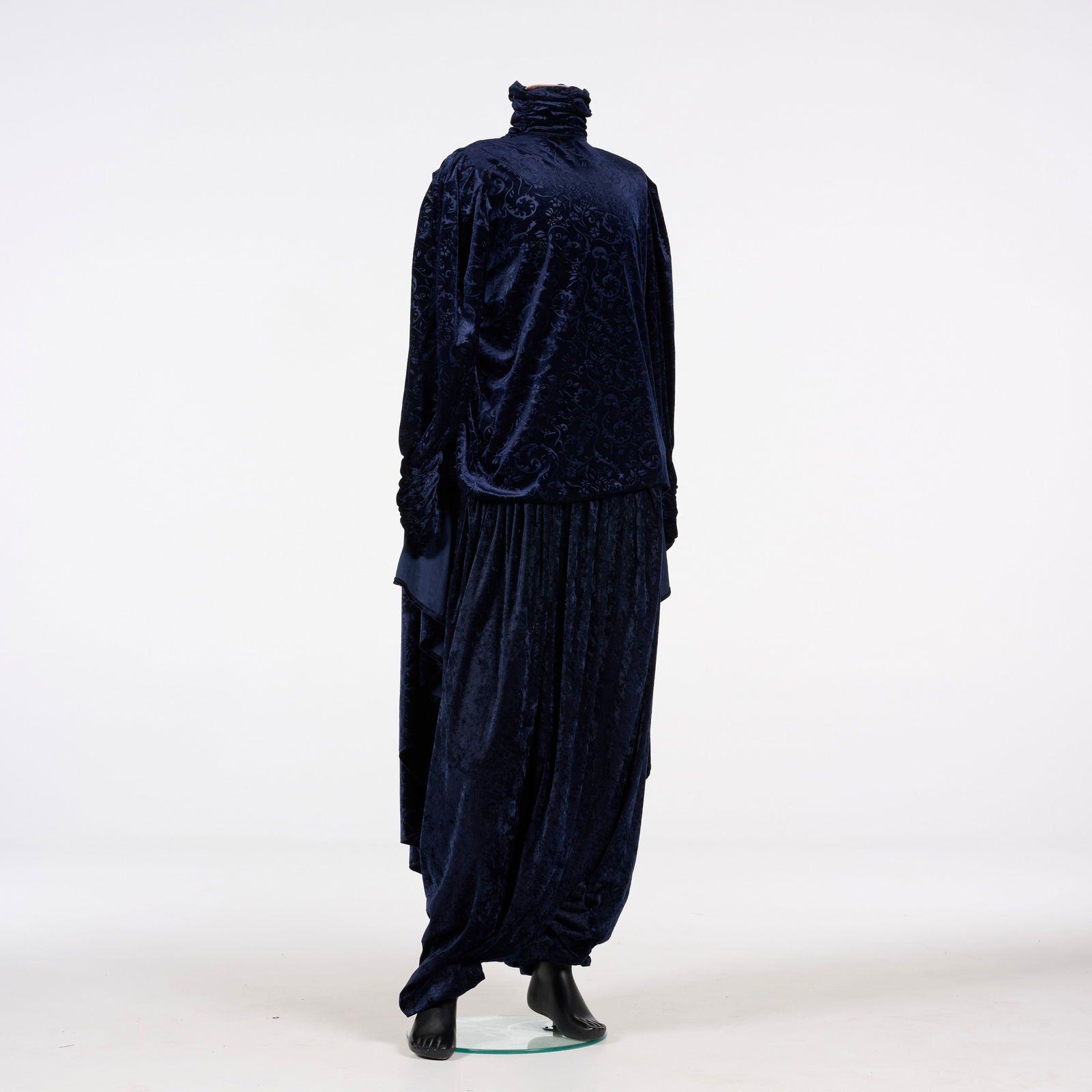 Original Costume Used by Royce to Perform the "Mirror" Illusion: Original costume used by Royce to perform the "Mirror" Illusion. This navy blue costume is crafted from a textured, patterned velvet featuring tonal floral scrollwork throughout the fabric. The back e