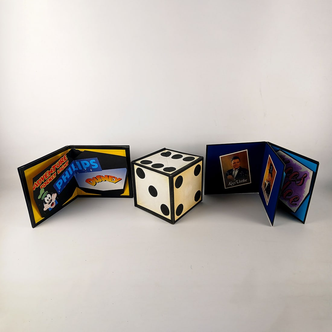 Lot of 3 Magic Tricks from the Royce Collection - 2 Crazy Dot Dice Folders and a Fold-out Dice Cube: Lot of 3 magic tricks from the Royce collection - Crazy Dot Dice Folder promoting Philips Pen Light and another promoting Dutch musician Kees Verlee, and a vintage fold-out dice cube. Dimensions (H x