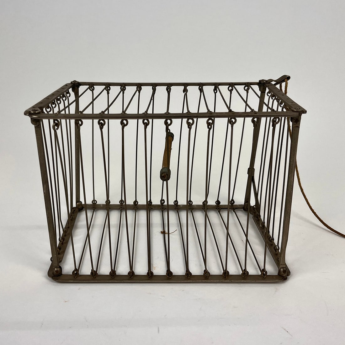 Foldable Bird Cage Magic Trick: Foldable bird cage magic trick. The magician asks a few helpers on stage, they all cover the bird cage with their hands, and in a blink of the eye the magician disappears the bird cage. Including pull