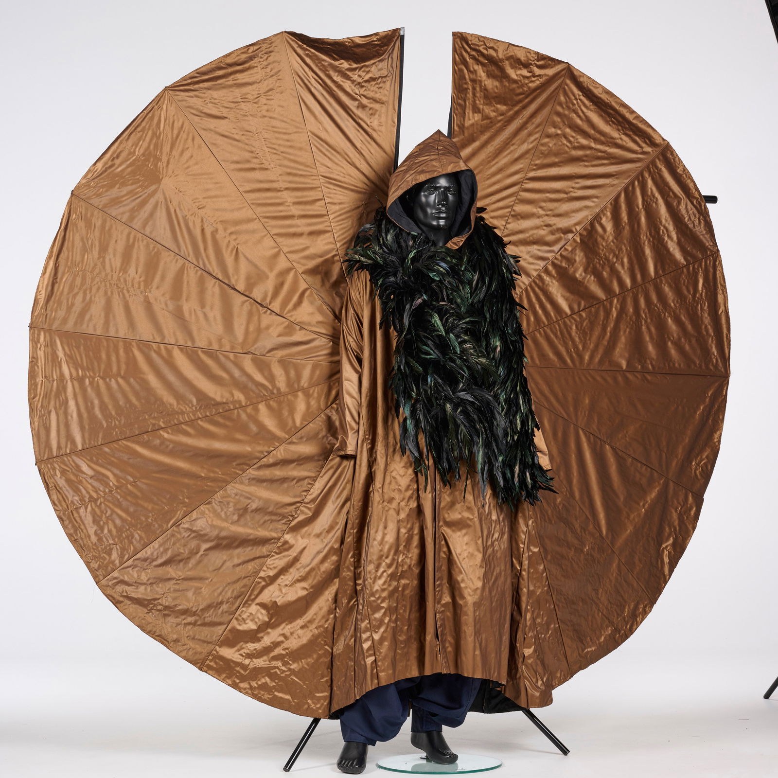 Original Walking Act Costume "Flying Monk" with Bronze "Wings" and Large Feather Boa: Original walking act costume "Flying Monk" from the Royce Collection. This theatrical costume features a shimmering bronze metallic hooded cloak paired with an oversized, fan-like wing structure and a