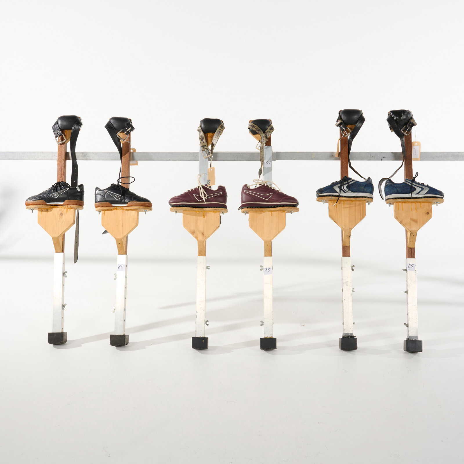 Three Pairs of 75 cm Tall Wooden Stilts with Footwear Bolted Directly Onto the Wooden Footplates: Three pairs of 75 cm tall wooden stilts, from the Royce Collection. These three pairs of stilts feature sneakers bolted onto custom wooden foot platforms. Each stilt is built with a sturdy wooden fram