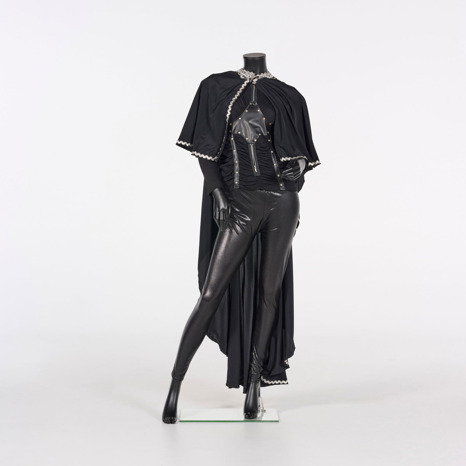 Original Black Three-piece Theatrical Costume Stage-worn by Royce's Assistant During Stage Illusions: Original black three-piece theatrical costume stage-worn by Royce's assistant during stage illusion performances. This three-piece theatrical ensemble features a dramatic, long-flowing black cape, a s