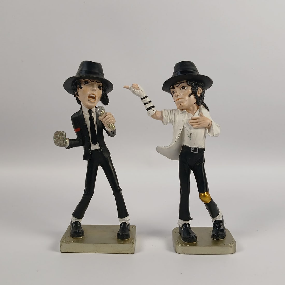 Set of 2 Michael Jackson Collectible Figurines: Set of 2 Michael Jackson collectible figurines in good visual condition showing spots of paint loss. Dimensions (H x W x D): 25 x 10 x 5 cm. Condition: Good. Location: The Netherlands, Tilburg.
