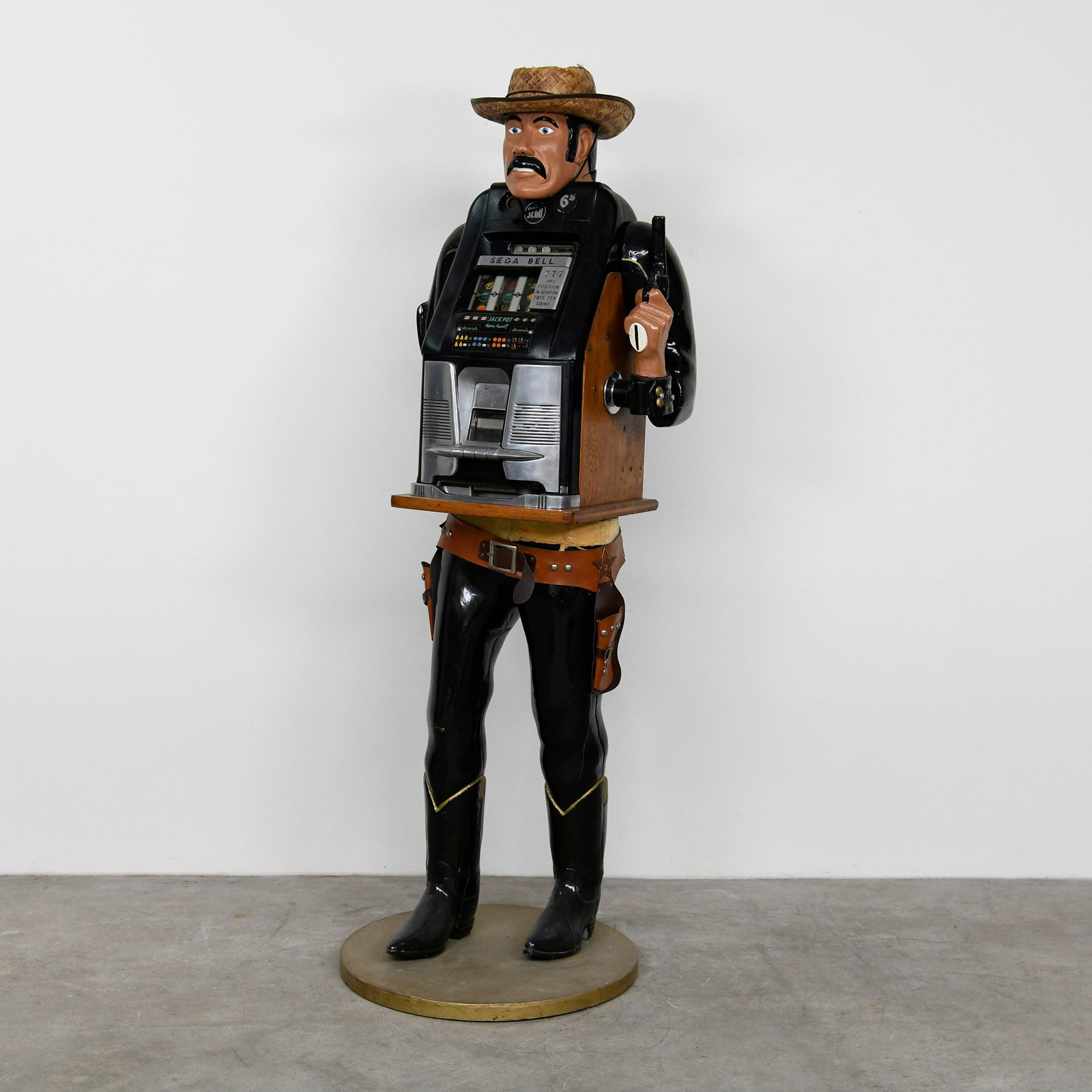 Sega Bell "Cowboy" Slot Machine (late 1950s): Sega Bell "Cowboy" Slot Machine (late 1950s). The item is a vintage slot machine housed within a full-size, painted cowboy figure made of a composite material, likely fiberglass, standing on a round g