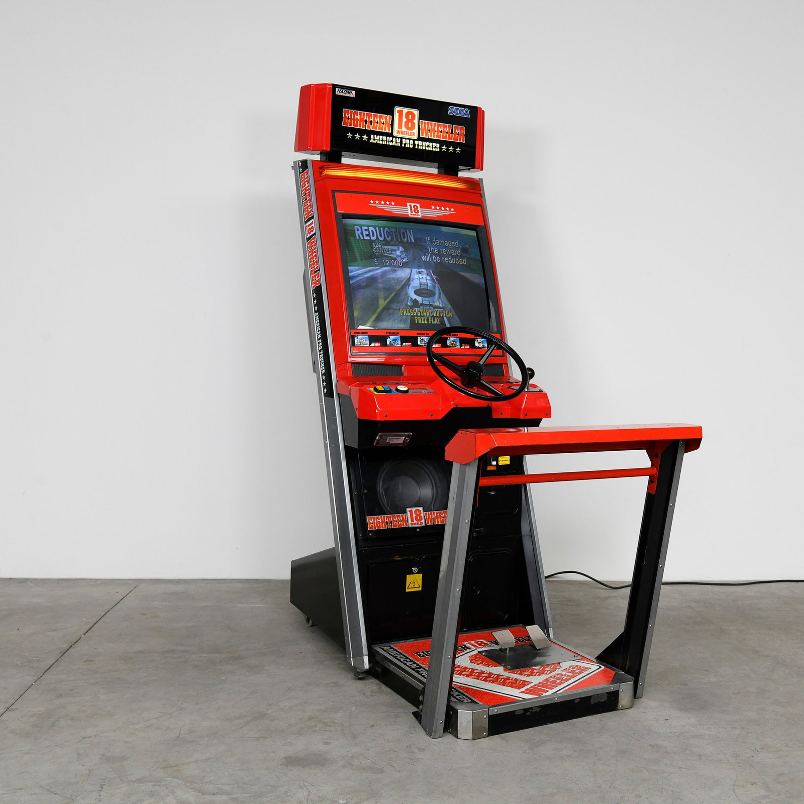 18 Wheeler: American Pro Trucker Sega Arcade Game (1999): "18 Wheeler: American Pro Trucker" by SEGA, produced in 1999, is in working condition. The cabinet is primarily red and black with silver accents, featuring game-specific artwork visible on the marque