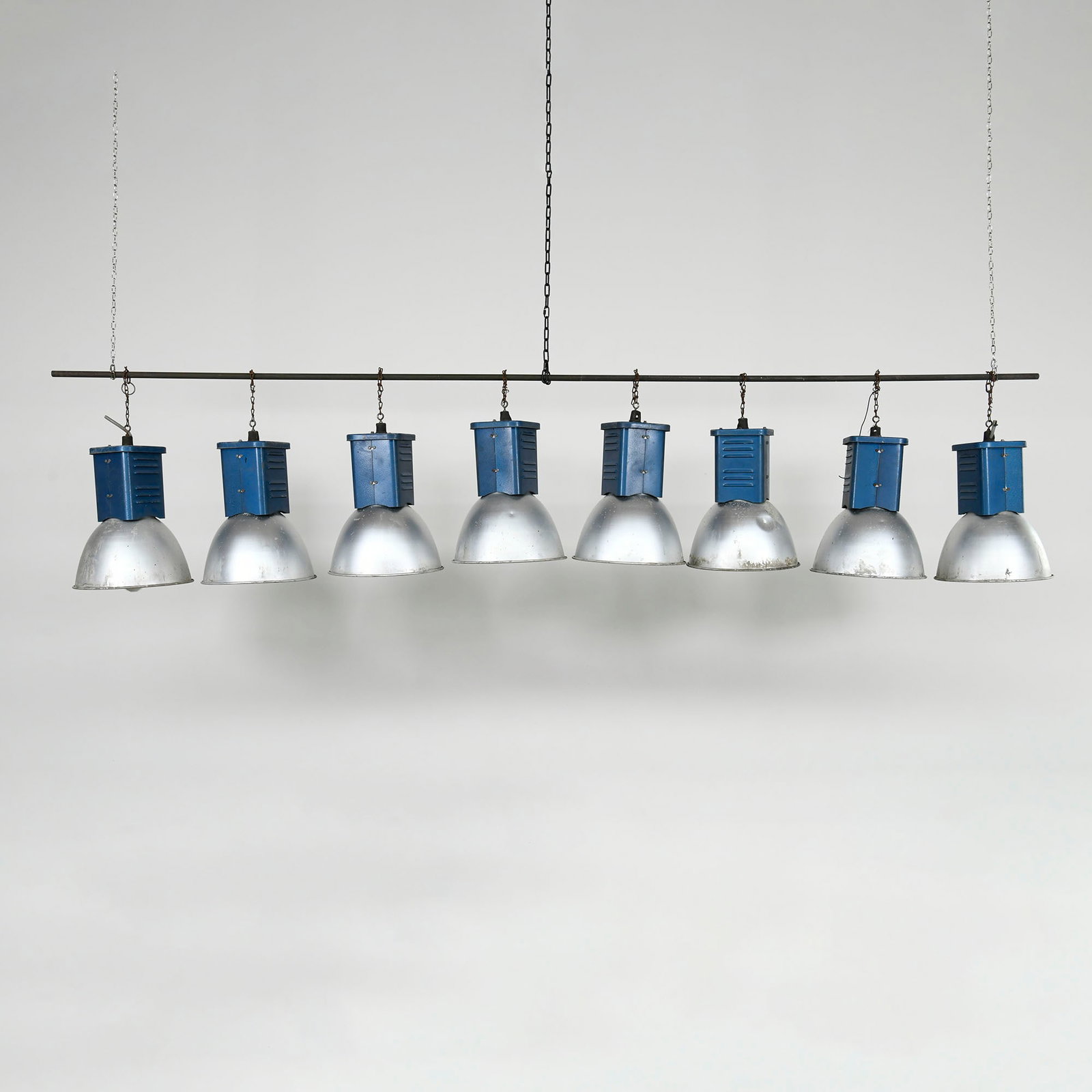 Set of 8 Vintage Mid-century Industrial Pendant Lamps: Set of eight vintage mid-century industrial pendant lamps. Each fixture features a blue hammer-tone painted steel upper housing with side ventilation louvers, suspended by short mounting chains, set a