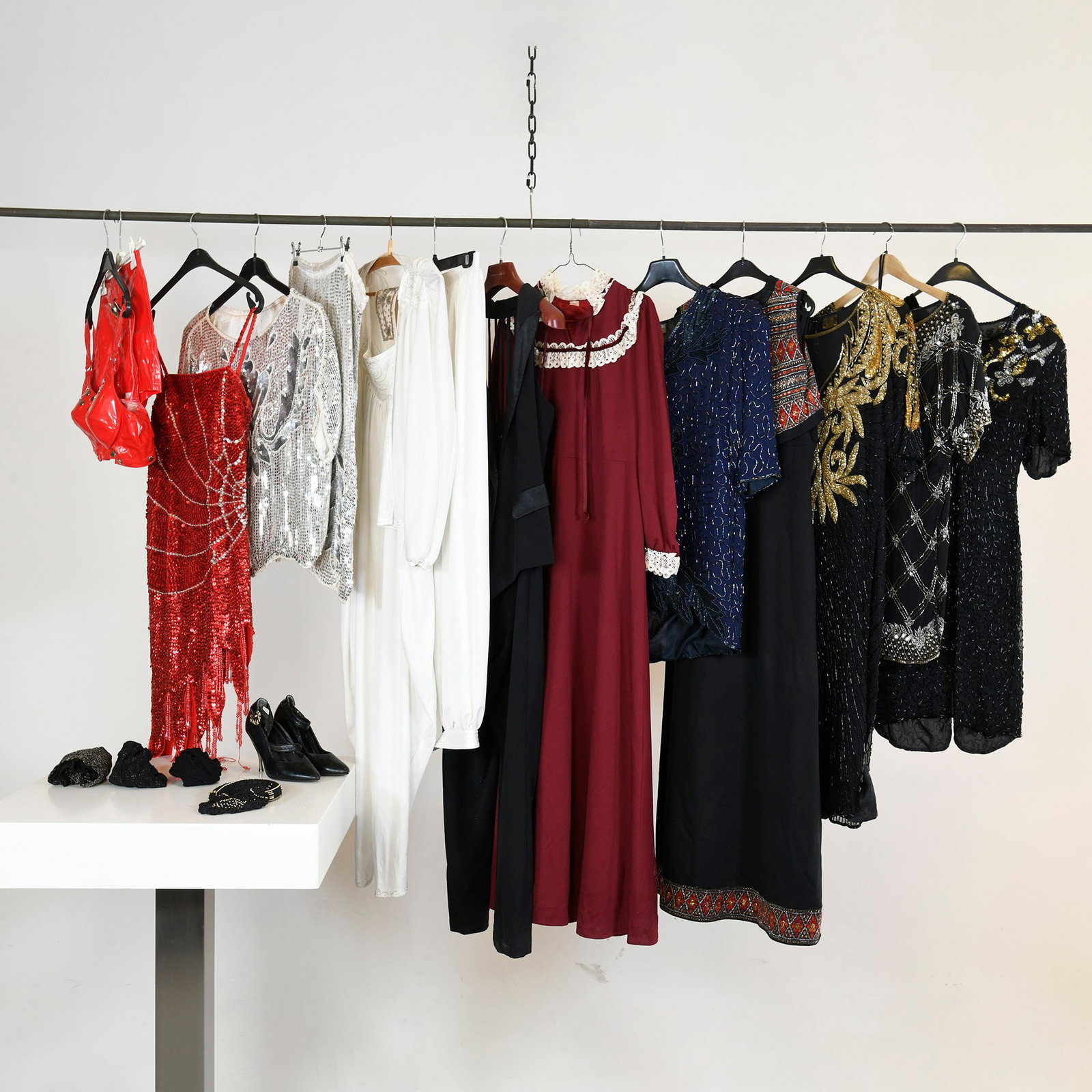 Collection Of Women's Stage Performance Costumes And Accessories: A collection of women's stage performance costumes and accessories, including a red patent leather bra and shorts set, a red sequined fringed spaghetti strap dress, a silver sequined short-sleeved top