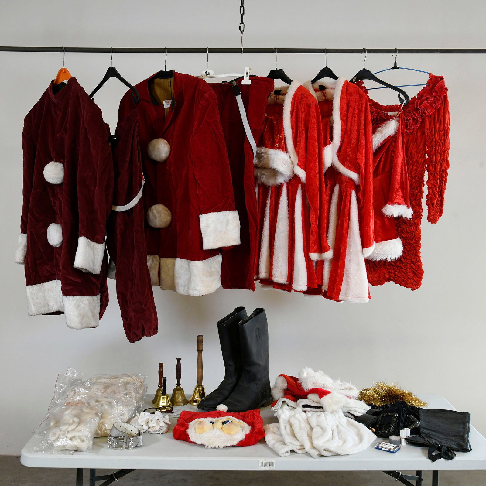 Various Vintage Santa Claus Costumes & Accessories: A comprehensive collection of professional Santa Claus costumes and accessories, including multiple red velvet-like Santa coats/jackets (some darker burgundy, some brighter red) with white faux fur tr